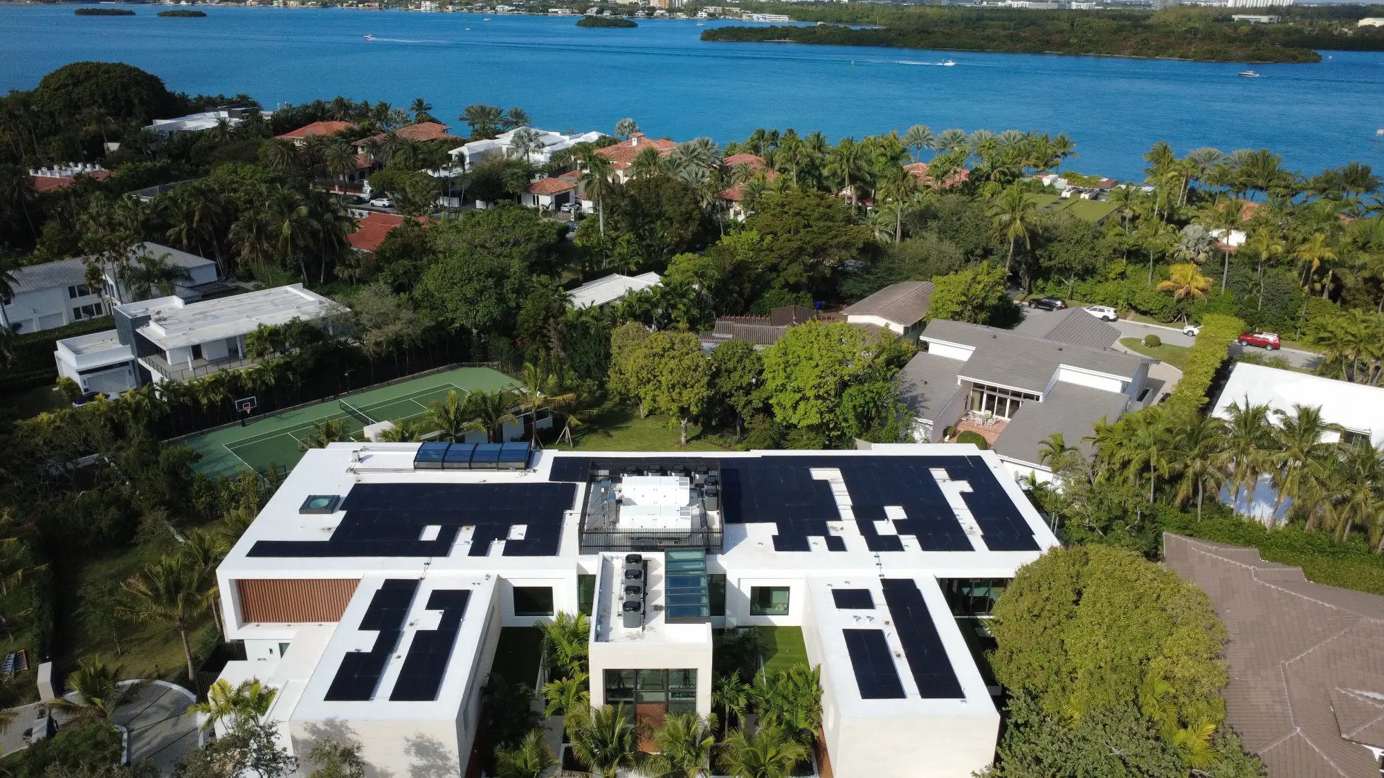 Rooftop solar arrays on a modern Florida home near the water